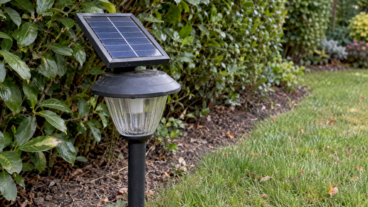 Lampa solarna z panelem w ogrodzie